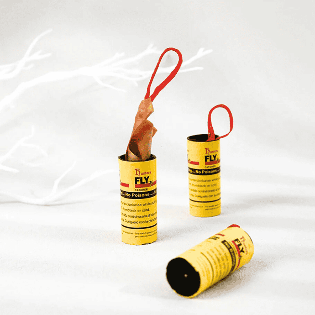 Yellow fly traps with red strings on a white background